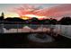Backyard view with a fire pit, lake view, and pink sunset at 5627 War Admiral Dr, Wesley Chapel, FL 33544