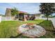 Backyard view, showcasing the screened-in lanai and a cozy fire pit area at 5627 War Admiral Dr, Wesley Chapel, FL 33544