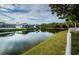 Backyard with a serene lake view, lush greenery, and white picket fence at 5627 War Admiral Dr, Wesley Chapel, FL 33544