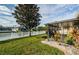 Landscaped backyard features a lush lawn, screened lanai, and tranquil lake view at 5627 War Admiral Dr, Wesley Chapel, FL 33544