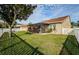 This home features a large, green backyard, a white fence, and screened in patio at 5627 War Admiral Dr, Wesley Chapel, FL 33544