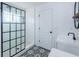 Modern bathroom with subway tiled shower, black hardware, and pattern tile flooring at 5627 War Admiral Dr, Wesley Chapel, FL 33544