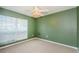 Empty bedroom with a ceiling fan, carpet flooring and a large window providing natural light at 5627 War Admiral Dr, Wesley Chapel, FL 33544