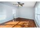 Spacious bedroom featuring wood flooring, ceiling fan, and a view of a bathroom at 5627 War Admiral Dr, Wesley Chapel, FL 33544