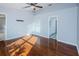 Bright bedroom featuring wood flooring, ceiling fan, and an open doorway to a bathroom at 5627 War Admiral Dr, Wesley Chapel, FL 33544