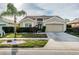 Charming single-story home featuring a manicured lawn, mature landscaping, and a two-car garage at 5627 War Admiral Dr, Wesley Chapel, FL 33544