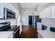 Modern kitchen with stainless steel appliances, white cabinets, and wood-look flooring at 5627 War Admiral Dr, Wesley Chapel, FL 33544