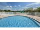 Community pool featuring clear blue water, surrounded by lounge chairs and umbrellas at 5627 War Admiral Dr, Wesley Chapel, FL 33544