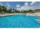 Large community pool with crystal clear water, sun loungers, and a fenced perimeter at 5627 War Admiral Dr, Wesley Chapel, FL 33544