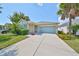 House exterior featuring light beige color, teal garage door, and landscaping at 6836 Park Strand Dr, Apollo Beach, FL 33572