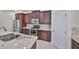 Well-equipped kitchen featuring granite countertops and dark wood cabinets at 6836 Park Strand Dr, Apollo Beach, FL 33572