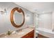 Stylish bathroom features a vanity with granite countertop and a unique round mirror at 175 2Nd S St # P-08, St Petersburg, FL 33701