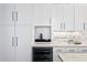 Modern kitchen featuring white cabinets, marble backsplash, wine fridge, and built in coffee maker at 175 2Nd S St # P-08, St Petersburg, FL 33701
