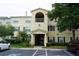 Two-story condo building with light yellow exterior, balconies, and ample parking at 18235 Bridle Club Dr # 18235, Tampa, FL 33647