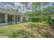 Spacious backyard featuring a screened-in lanai, lush landscaping, and mature trees at 21550 Clubside Loop, Lutz, FL 33549