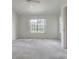 Bright bedroom with large window, neutral carpet, and ceiling fan at 21550 Clubside Loop, Lutz, FL 33549