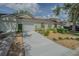 Front view of home featuring attached garage, well-manicured landscaping, and a concrete driveway at 21550 Clubside Loop, Lutz, FL 33549