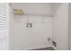 Bright laundry room with white walls, wire shelving, and modern flooring at 21550 Clubside Loop, Lutz, FL 33549