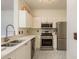 Modern kitchen with stainless steel appliances and white cabinets at 2749 Via Cipriani # 1032A, Clearwater, FL 33764
