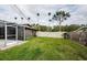 Landscaped backyard with grassy area and screened enclosure at 3311 San Mateo St, Clearwater, FL 33759