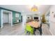 Bright dining area with wood table and green chair, open to the living room at 3311 San Mateo St, Clearwater, FL 33759