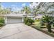 Cracked driveway leading to a two-car garage with gray siding at 5003 Belmont Rd, Tampa, FL 33647