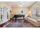 Elegant music room featuring a grand piano, comfortable seating, and hardwood floors at 5003 Belmont Rd, Tampa, FL 33647