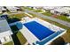 Community pool with a blue cover, surrounded by lush greenery at 5244 Montego Dr, Zephyrhills, FL 33541