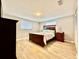 Well-lit bedroom with a wooden bed frame and light wood flooring at 6216 Fairway Blvd, Apollo Beach, FL 33572