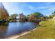 Scenic pond with a wooden bridge and fountain, surrounded by lush greenery and autumn foliage under a blue sky at 6388 93Rd N Ter # 4603, Pinellas Park, FL 33782