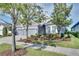 Single-story home with gray exterior, three-car garage, and well-manicured landscaping at 7506 Parkshore Dr, Apollo Beach, FL 33572