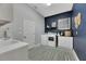 Laundry room with white cabinets, washer, dryer and blue accent wall at 7506 Parkshore Dr, Apollo Beach, FL 33572