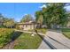 Charming home featuring well-manicured lawn, lush landscaping, and inviting curb appeal nestled among mature trees at 905 Lake Fuller Dr, Lutz, FL 33548