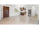 Open living room with tile floors, a built-in bookcase, a view of the kitchen, and neutral colored walls at 905 Lake Fuller Dr, Lutz, FL 33548