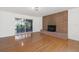 Bright living room with hardwood floors, a brick fireplace, and sliding doors that lead to the outside at 905 Lake Fuller Dr, Lutz, FL 33548