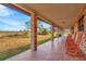 Spacious covered porch with tile flooring and orange rocking chairs at 9229 Fort King Rd Rd, Dade City, FL 33525