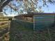 A side view of a large, green, metal-sided pole barn style shed on a sunny day at 9229 Fort King Rd Rd, Dade City, FL 33525