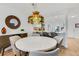 Dining room with round marble table, six chairs, and a stained glass light fixture at 947 Madrid Dr, Palm Harbor, FL 34684