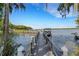 Private dock extending into a serene lake surrounded by lush greenery at 947 Madrid Dr, Palm Harbor, FL 34684