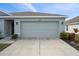 Two-car garage with light gray doors and exterior lighting at 10303 Charlotte Dr, Parrish, FL 34219