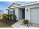 Front entry with dark gray door, landscaping, and walkway at 10303 Charlotte Dr, Parrish, FL 34219