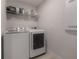 Bright laundry room with washer, dryer, and shelving at 105 W Osborne Ave, Tampa, FL 33603