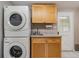 Clean laundry room with stacked washer and dryer and cabinets at 20735 Gardenia Dr, Land O Lakes, FL 34638