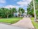 Two-story home with a brick driveway, lush landscaping, and palm trees at 334 Blanca Ave, Tampa, FL 33606