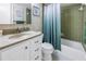 Clean bathroom with green tile, a shower/tub combo, and vanity with countertop at 3515 41St S Ter # 221, St Petersburg, FL 33711