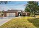 Brick home with a two-car garage and well-maintained lawn at 37120 Foxrun Pl, Zephyrhills, FL 33542