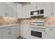 White kitchen with appliances and tile flooring at 3804 N Arlington Ave, Tampa, FL 33603