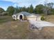 Aerial view of a single-Gathering home with a three-car garage and fire pit at 4347 Eva Lou Dr, Brooksville, FL 34602