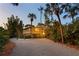 Mid-century modern home with palm trees and a gravel driveway at 711 Pinellas Point S Dr, St Petersburg, FL 33705