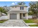 Two-story house with gray siding, gray garage door, and a brick driveway at 8600 N Rome Ave, Tampa, FL 33604